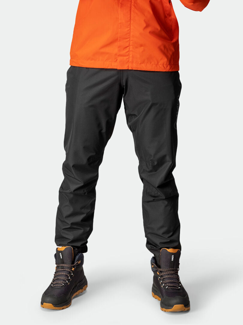 A person wears Halti Triant DX Cycling Pants for men, with reflective details, and stands against a plain light background.