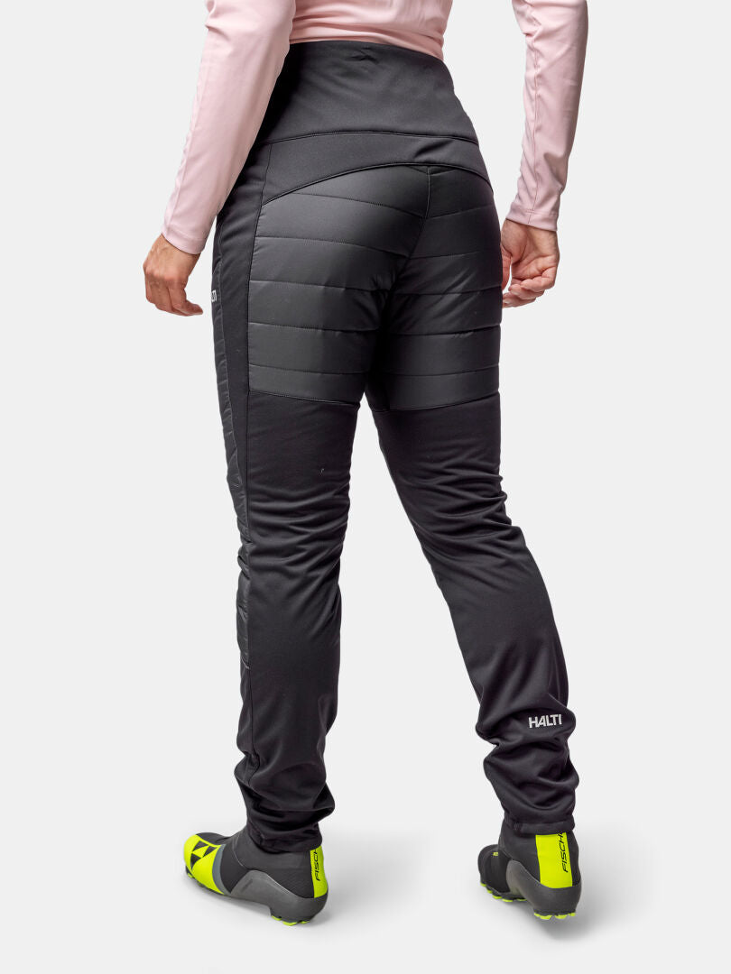 Person wearing Halti Hanki 2 Hybrid XCT Women's Pants, a light pink top, and yellow-black shoes on a white background.