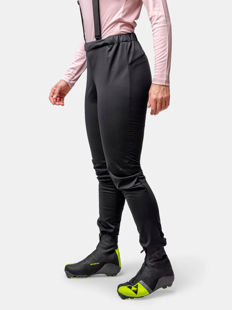 Woman wearing Halti Huuru XC Set and neon yellow cycling shoes, ideal for winter training or cross-country skiing.