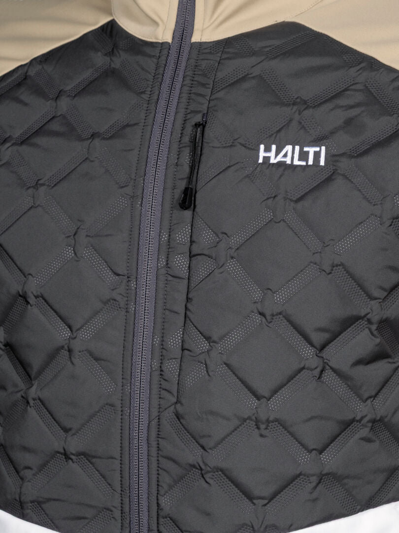 Close-up of Halti Framover Hybrid XCT Jacket Men's, quilted black with a vertical zipper and white logo on the chest.