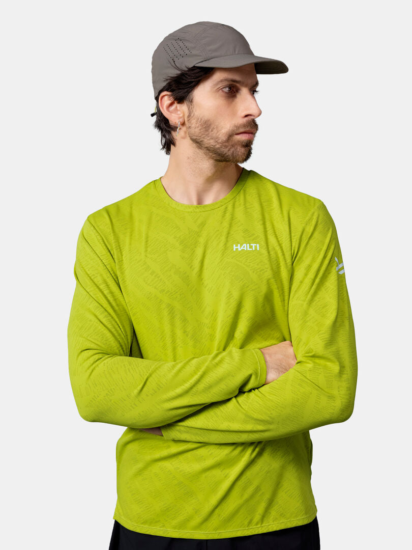 Man in a gray cap and Halti Oulanka Training Shirt stands with arms crossed, looking to his left.