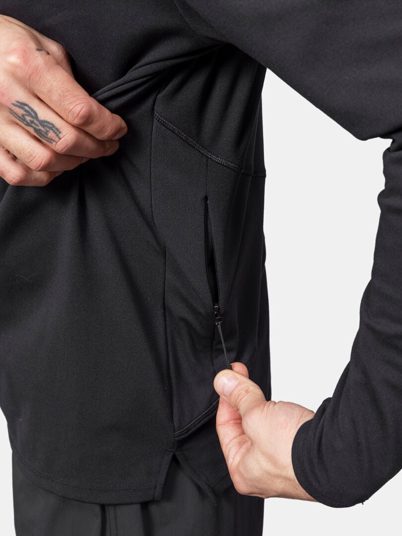 A person shows the zippered side pocket of the black Halti Kaltio Training Hoodie Men's, partially unzipped.