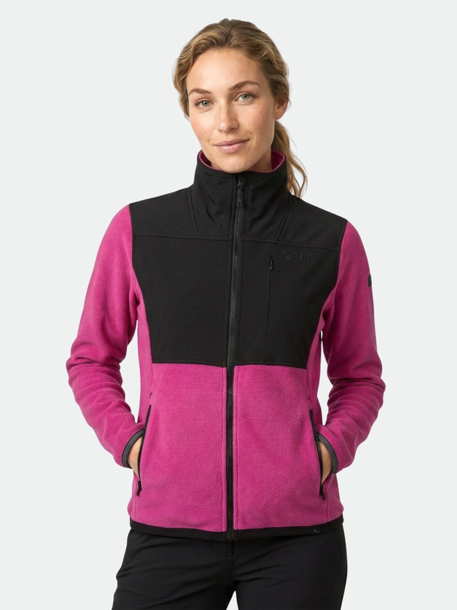 Halti Pioneering Women's Fleece Jacket features black top panels, magenta lower panels, and handy pockets.