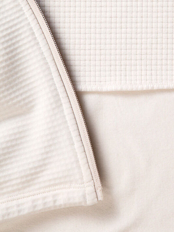 Close-up of recycled polyester fabric from Halti's HeatGrid Layer Jacket Women's, showing ribbed, grid, and smooth textures.