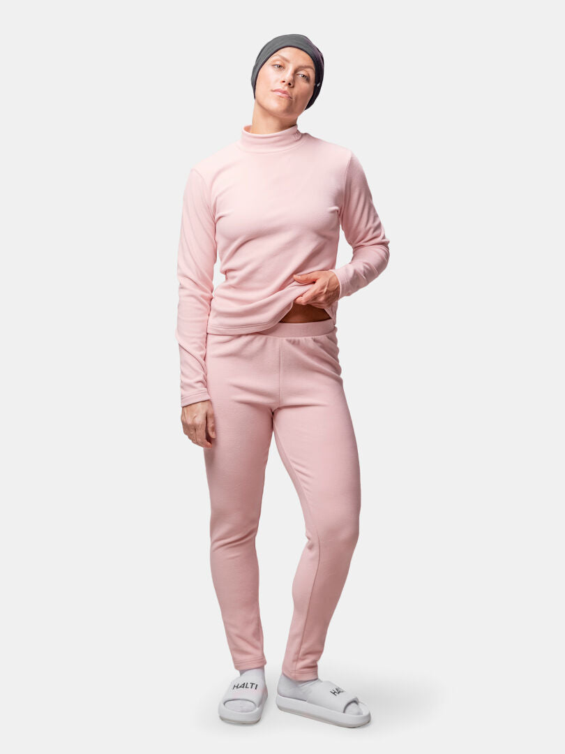 Woman wearing the Halti Trone Fleece Shirt and pants, gray beanie, and white slippers against a plain background.