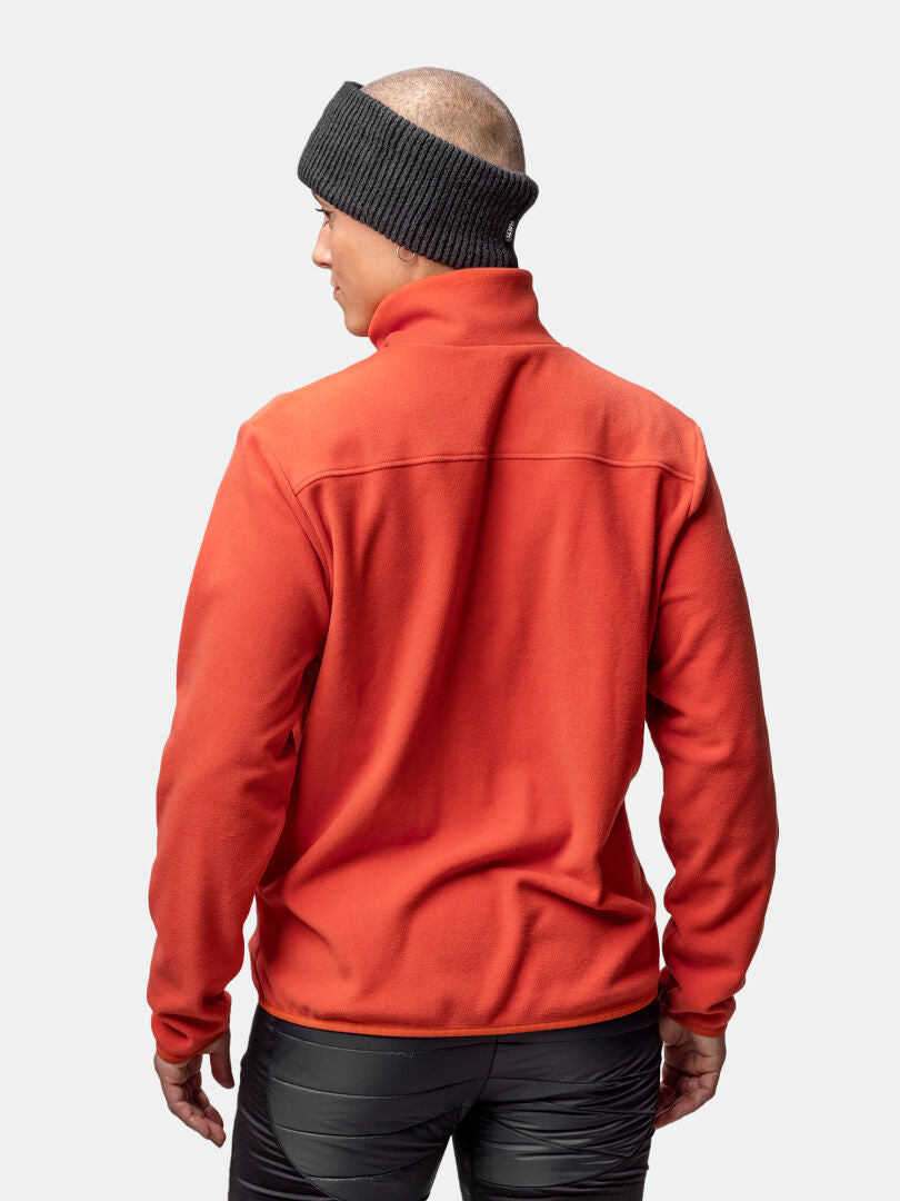 A person wears a red Halti Rockmoon Fleece Jacket Women's with a black headband and pants against a plain background.