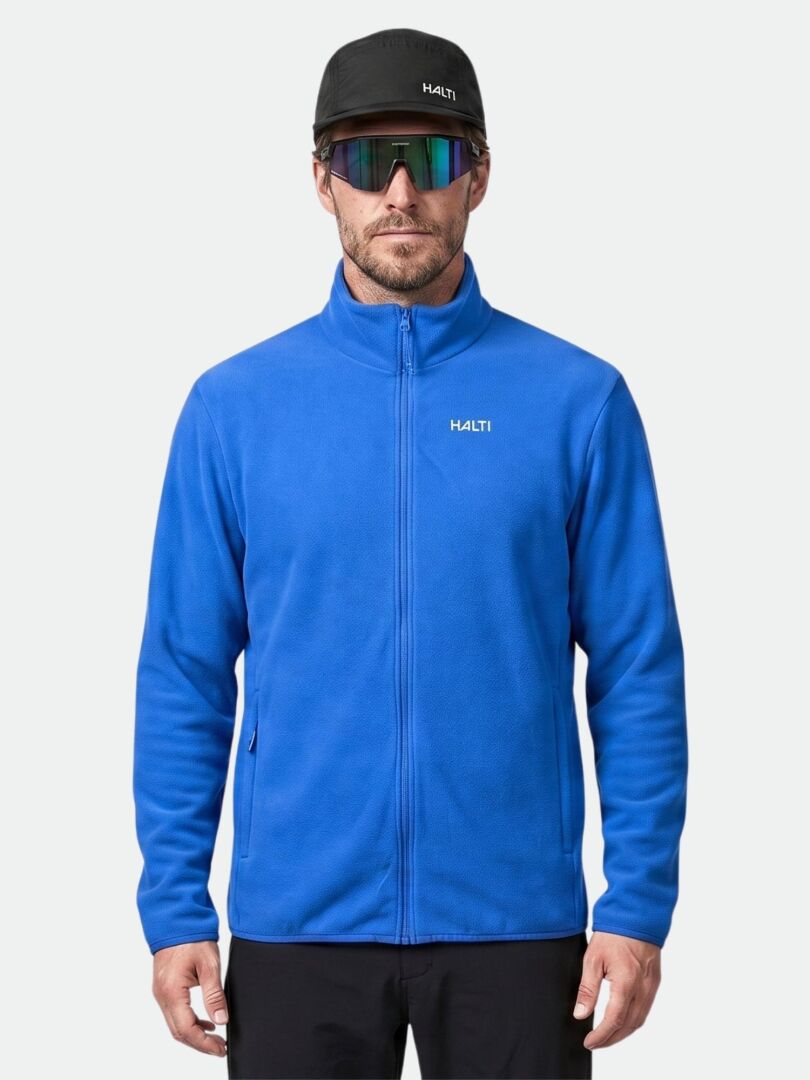 A man wears the Halti Rockmoon Fleece Jacket, a black cap, and reflective sunglasses against a plain background.