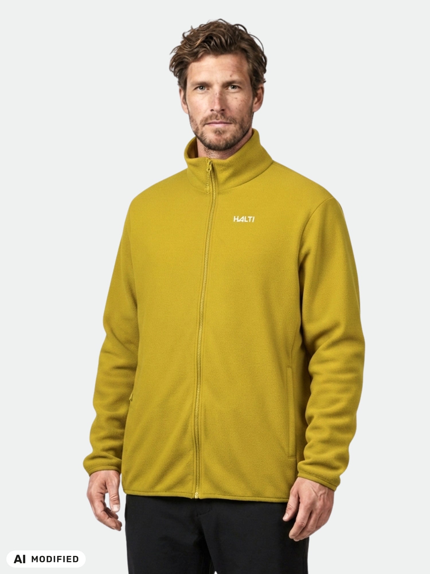 A man wears a mustard yellow Halti Rockmoon Fleece Jacket, perfect as a stretchable thermal midlayer.