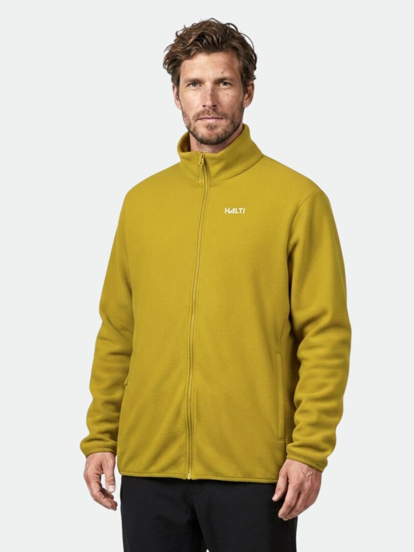 A man wears a mustard yellow Halti Rockmoon Fleece Jacket, perfect as a stretchable thermal midlayer.