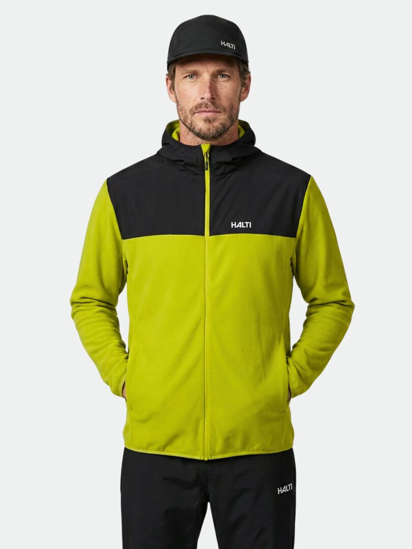 A man wears the Halti Rockmoon Fleece Hoodie, black pants, and a cap, standing and facing forward.