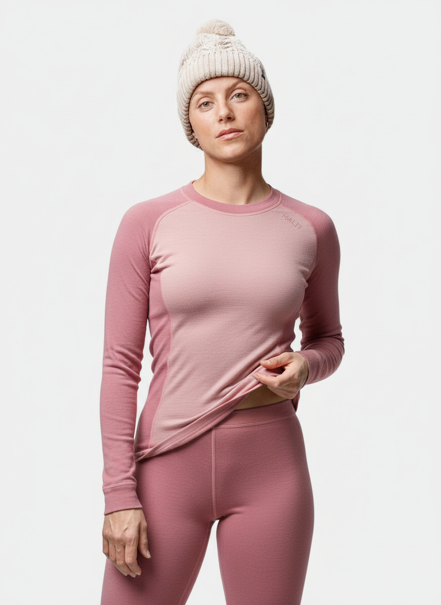 Model wears the Halti Hossa II Merino Base Layer Set Women's in pink and a cream knit beanie against a white background.