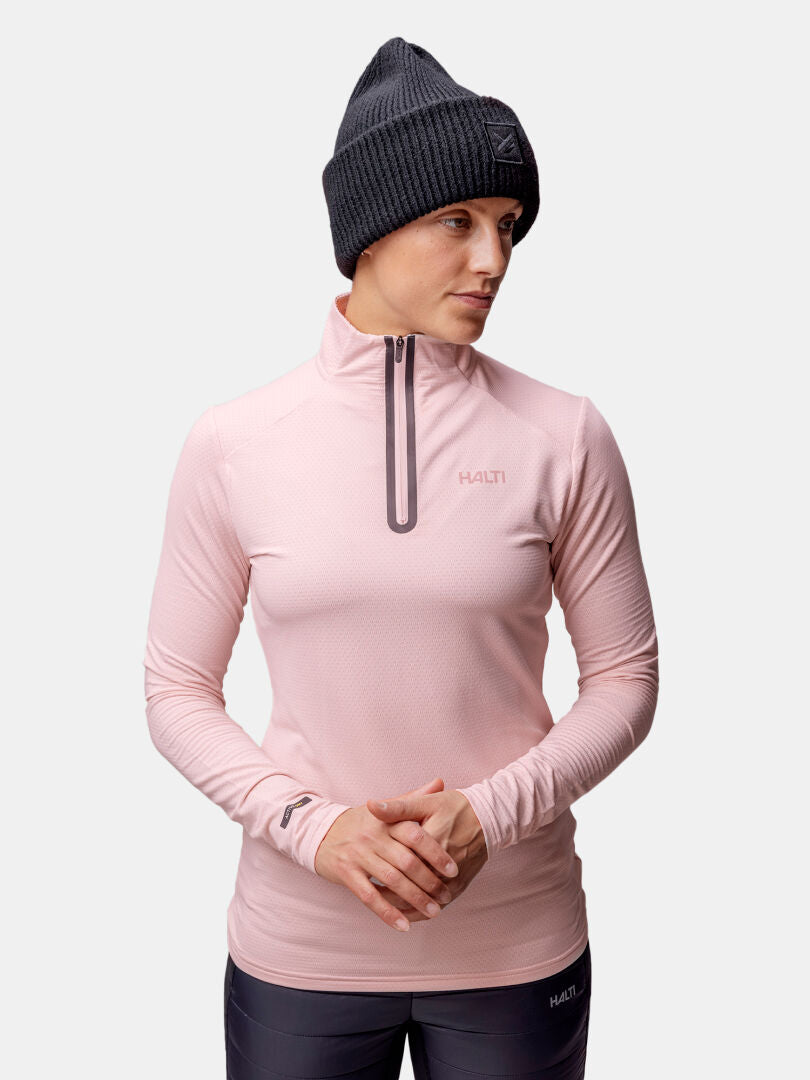 Model wears the Halti Jaako Shirt Women's in pink with a dark knit beanie, standing against a plain light background.