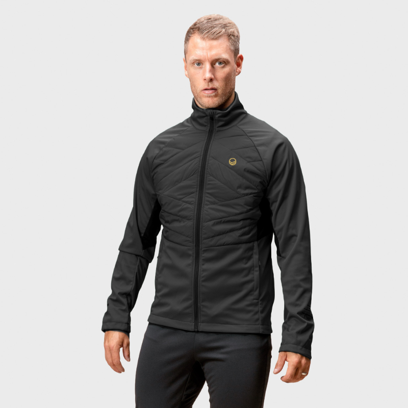 A man faces forward in a Halti Vinha Hybrid XCT Jacket and black pants against a plain light gray background.