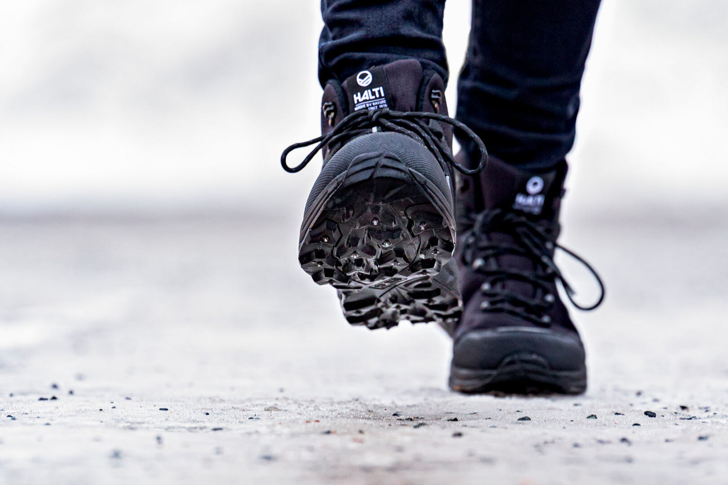 Close-up of a person in Halti Lynx Womens Mid DrymaxX Spike Shoes walking on a rough surface.