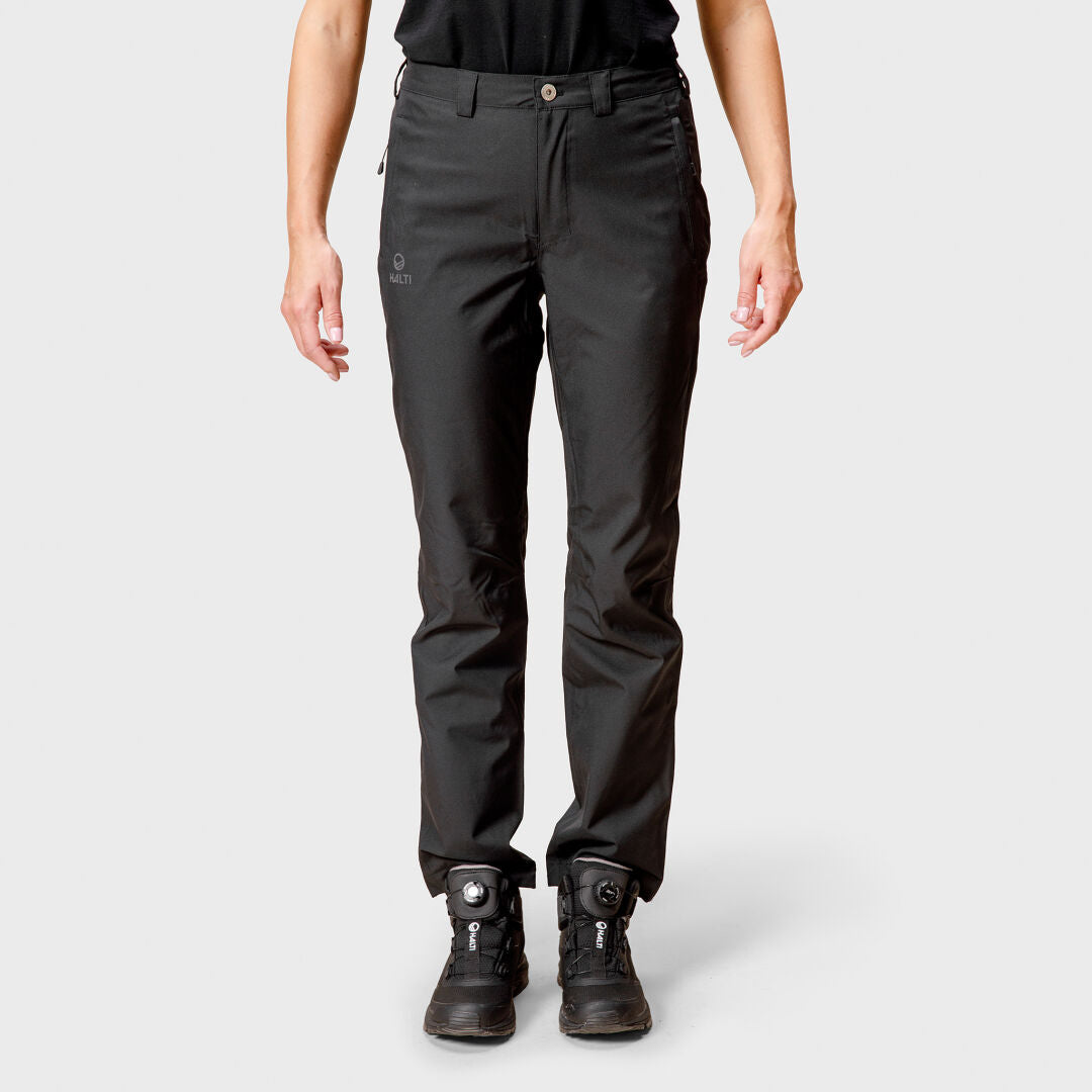 A person wears Halti Leisti DX Shell Pants for women and black boots, standing facing forward against a light gray background.