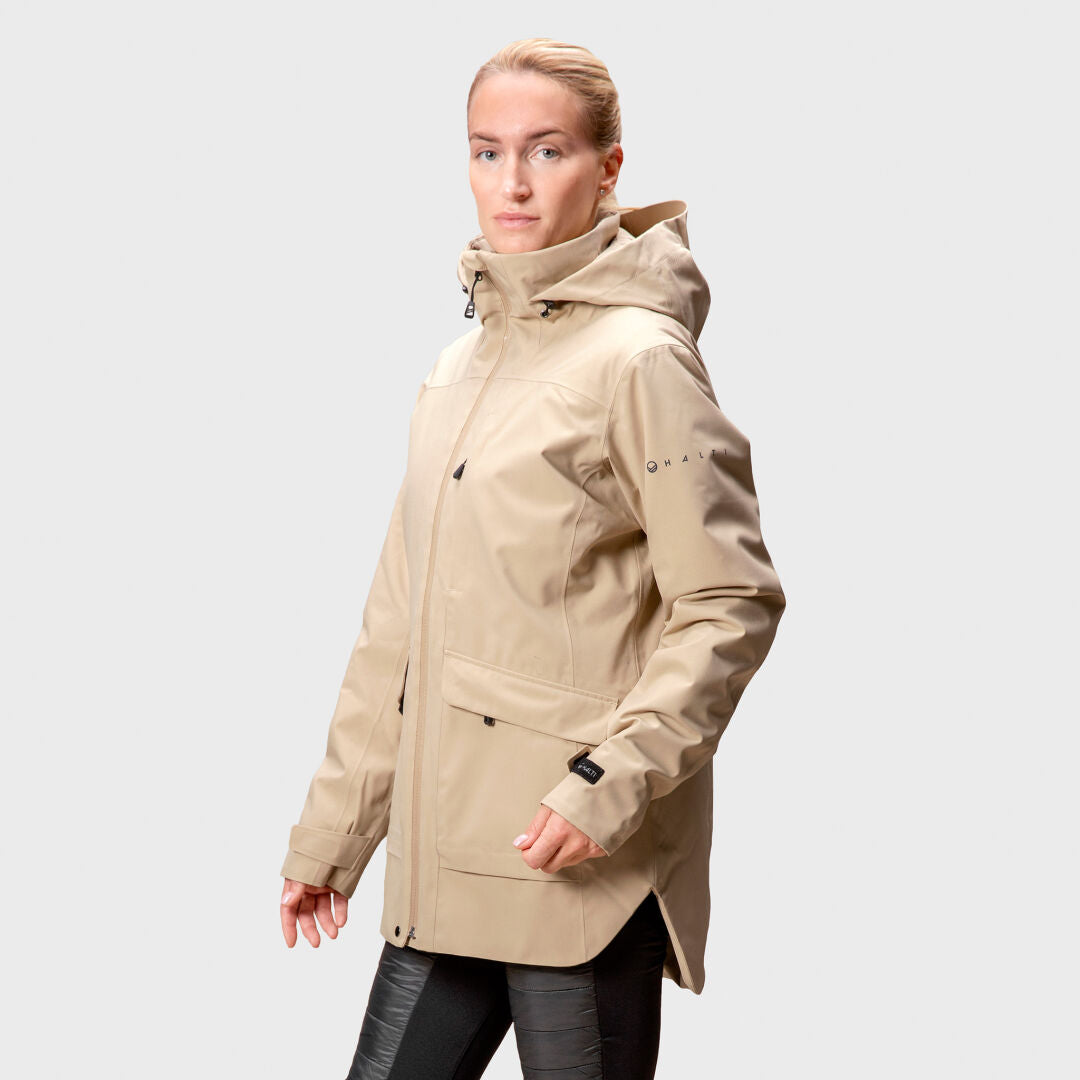 A person in a Halti Olhava DrymaxX Parka for women and black pants stands against a plain light gray background.