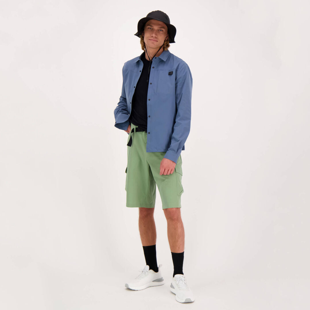 Model in a studio wears the Halti Bluusi Unisex Shirt with sporty accessories and green shorts.