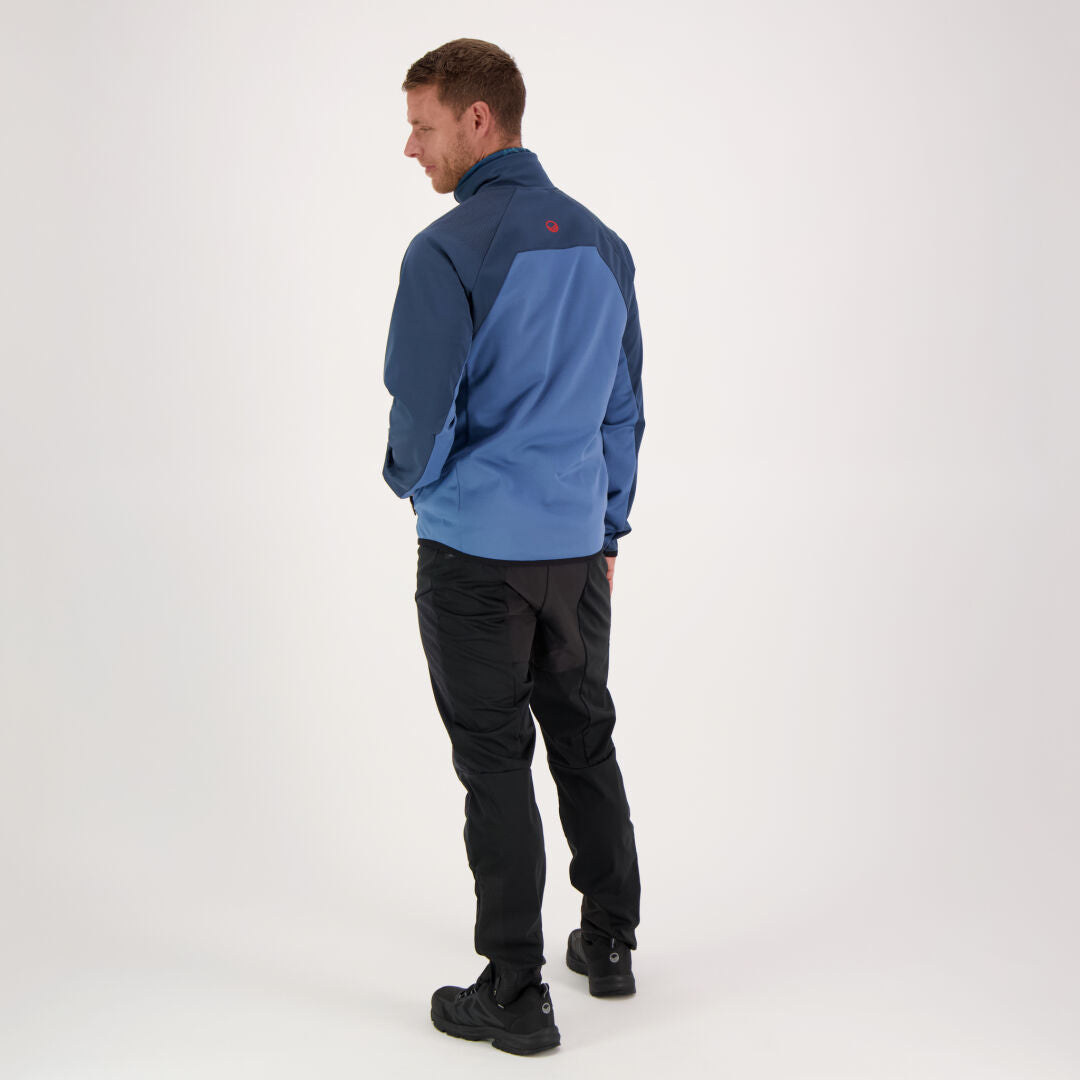A man models Halti Suunta Mens Hybrid Pants with a blue jacket and black shoes against a plain white background.