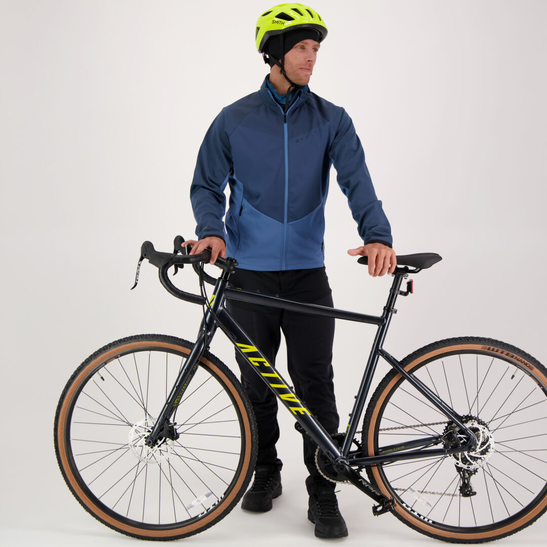 Person wearing Halti Suunta Mens Hybrid Pants, blue jacket, yellow helmet, standing with a black and yellow bike.