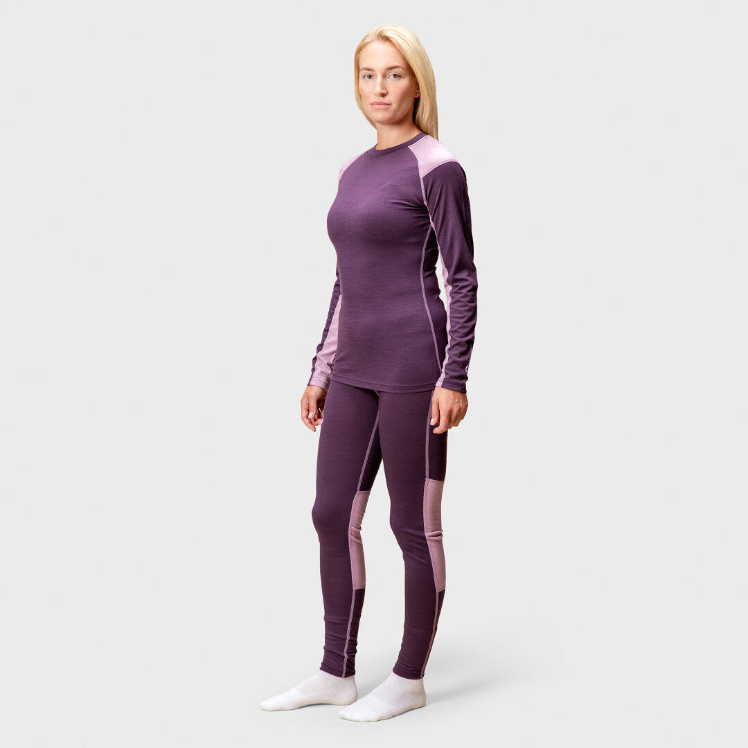 A woman faces forward, wearing the Halti Pihka II Merino Baselayer Shirt for women with white socks.