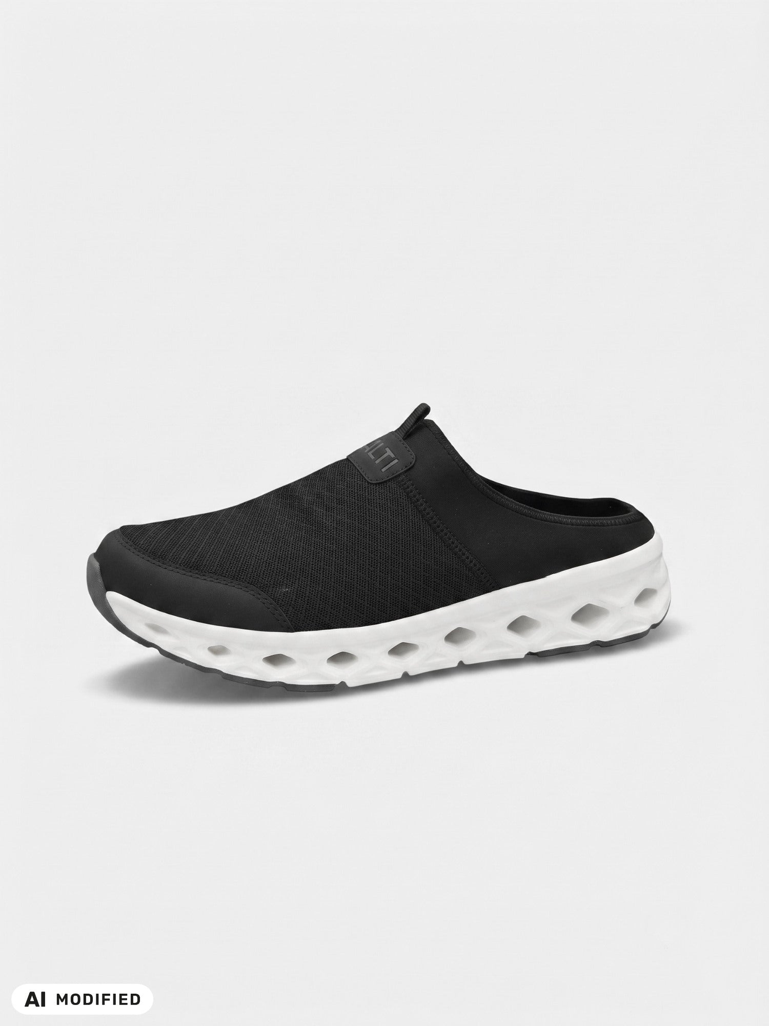 The Halti Lago 3 Sandal is a black slip-on with a mesh upper and white sole, shown on a light gray background.