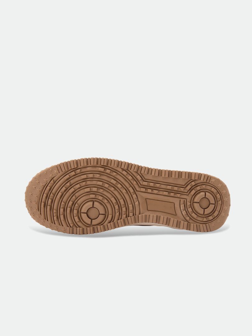 The image shows the brown rubber sole of Halti’s Metso Mid DX Men’s waterproof winter shoe on a white background.
