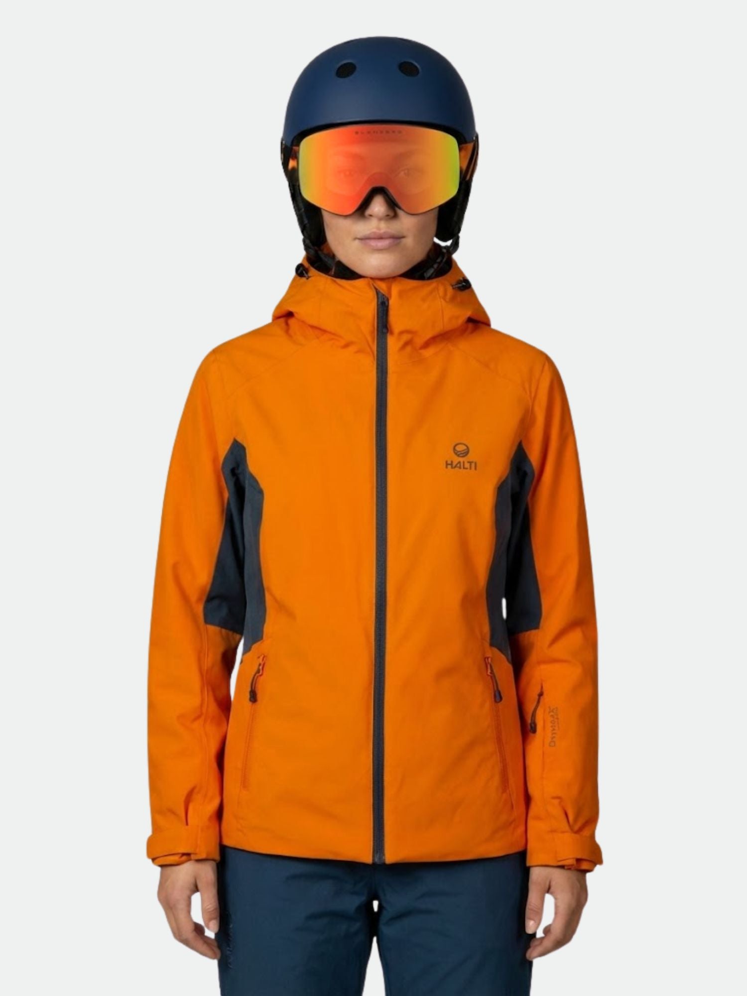 A person wears a Halti DX Ski Jacket Women's, dark helmet, and reflective goggles against a plain background.