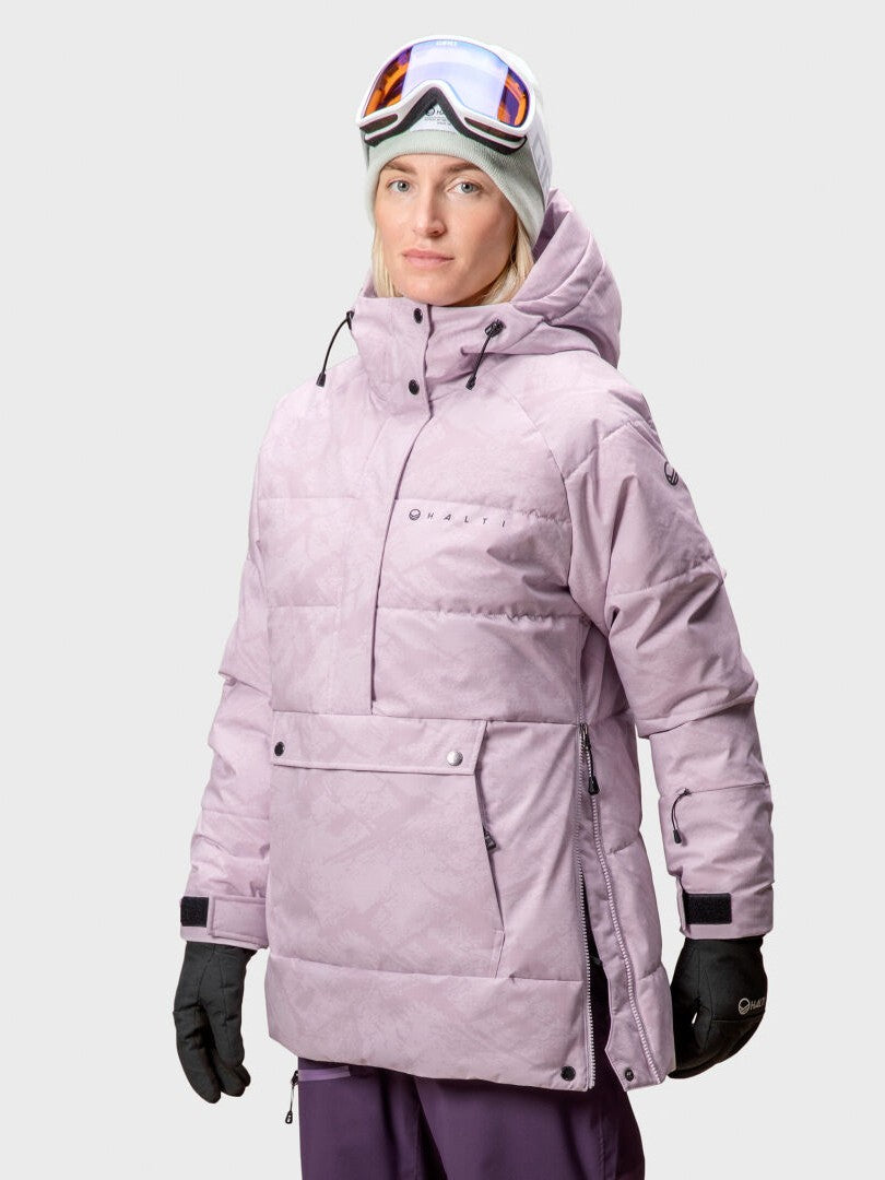 A person wears the Halti Chowper Ski Anorak Women's jacket, gloves, goggles, and a beanie against a plain background.