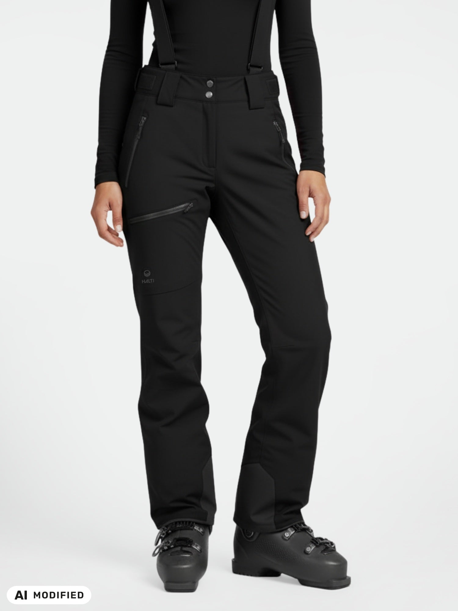 Model wears Halti Carvey DX Ski Pants for women with suspenders, black boots, and a fitted top against white background.