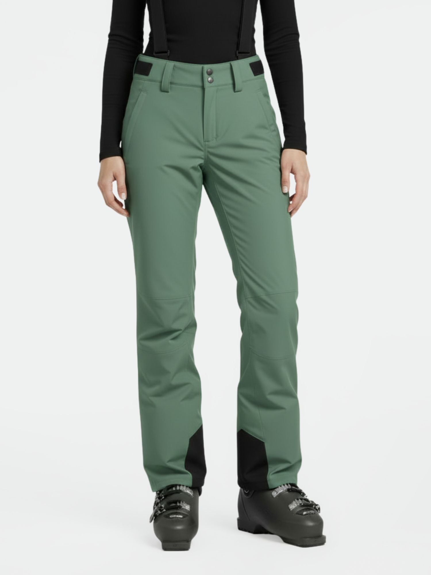 Someone wears Halti Trusty DrymaxX Women's sage ski pants with suspenders, a black top, and ski boots on white background.