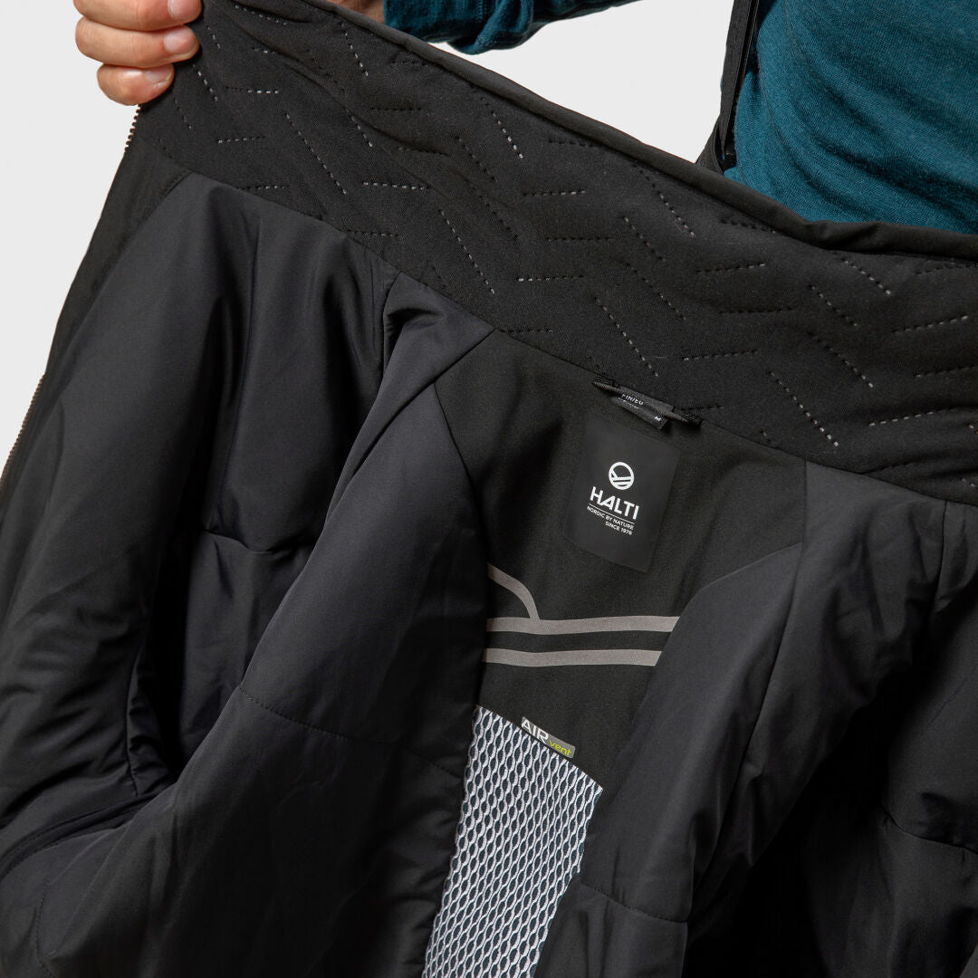 Person holding open a men's Halti Vertica DX ski jacket, revealing the interior lining and care label.