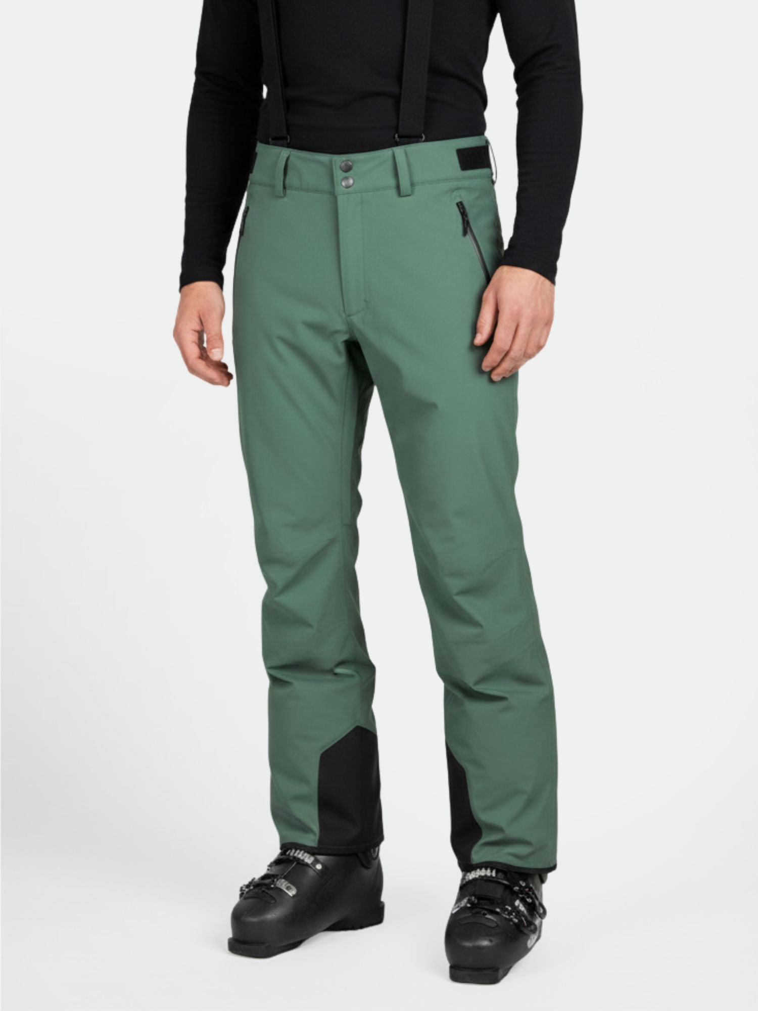 A man in Halti Trusty DrymaxX Ski Pants (green) with black suspenders, boots, and a black long-sleeve shirt.