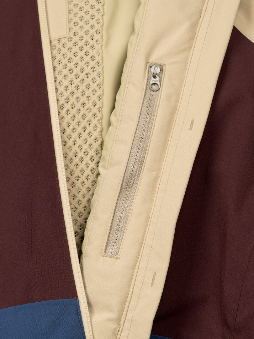 Close-up of Halti Gracer DX Ski Jacket Women's with beige zip pocket, mesh lining, and brown-blue fabric.