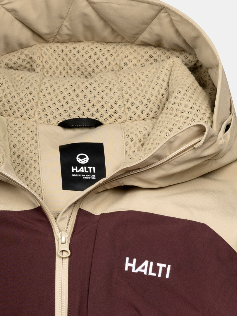 Close-up of a beige and maroon Halti Gracer DX Women's Ski Jacket with mesh-lined hood, zipper, and Halti logo.