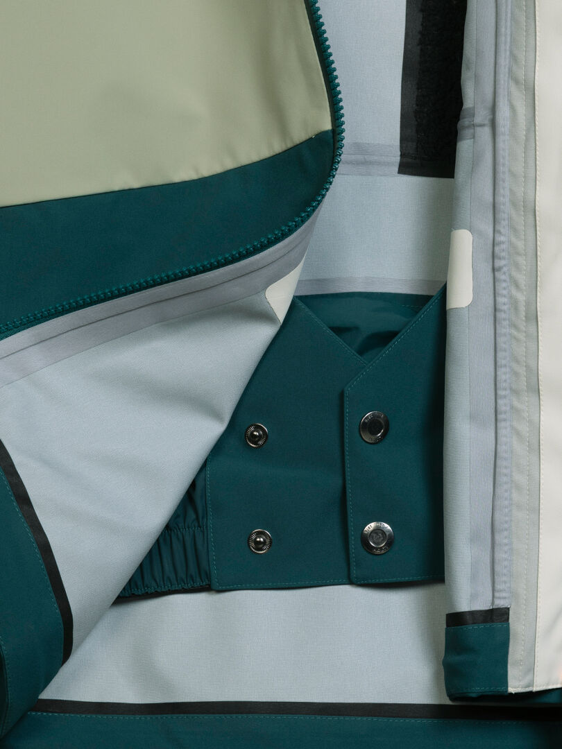 Interior view of an open Halti Rizle Unisex 3L DX Ski Jacket showing the powder skirt with snap buttons.
