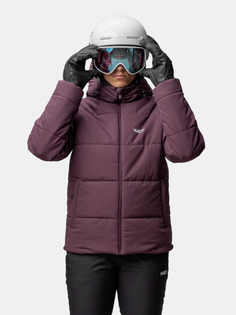 Model wears the Halti Ascale Puffer Ski Jacket for women, paired with black gloves, ski goggles, and a white helmet.