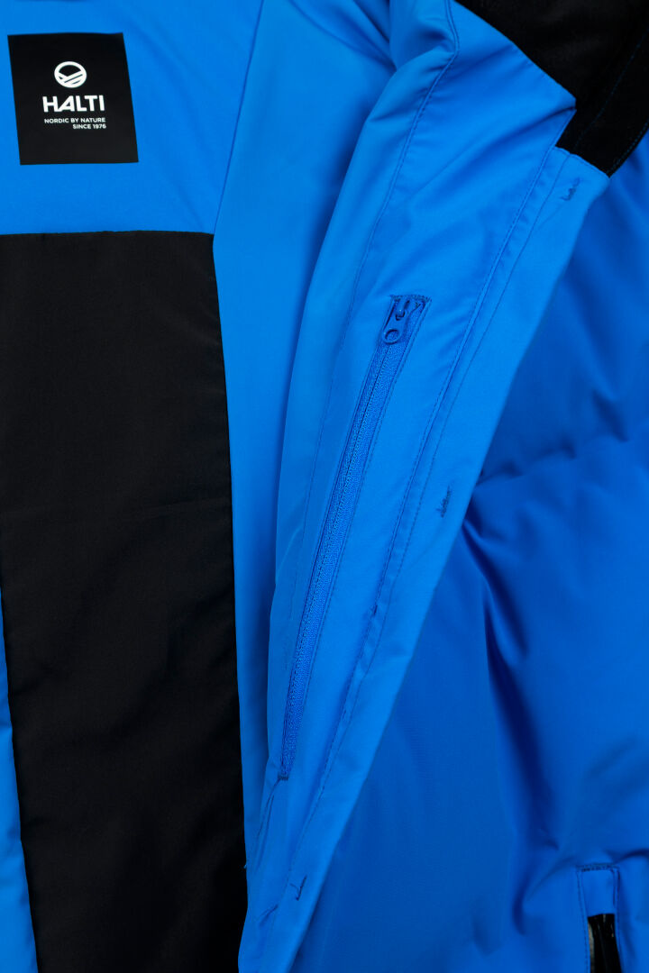 Close-up of the Halti Nordic Arcty II Men's Ski Jacket, featuring Arcty insulation, an interior zip pocket, and logo patch.