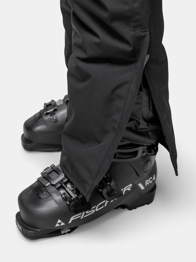 Close-up of Halti Glades II DX Ski Pants Women's over black Fischer RC4 ski boots, cuff partly unzipped.