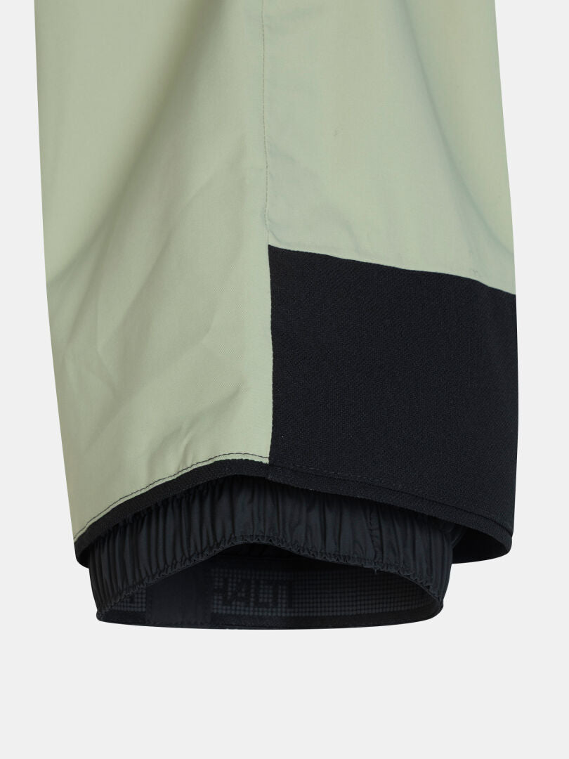 Light green Carvey II DX Ski Pants with a black reinforced inner cuff and an elasticized snow gaiter at the hem.