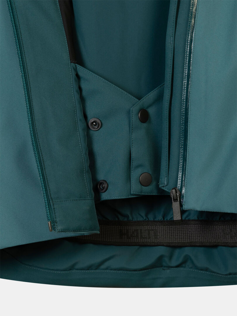 Teal Halti Recier DX Ski Jacket Men’s showing the interior powder skirt, snap buttons, and a zippered front closure.