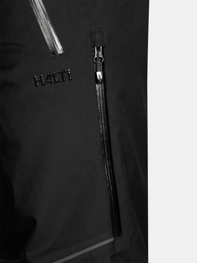 Close-up of black Halti Vertica II DX Ski Pants Men’s featuring a vertical zippered pocket and a logo.