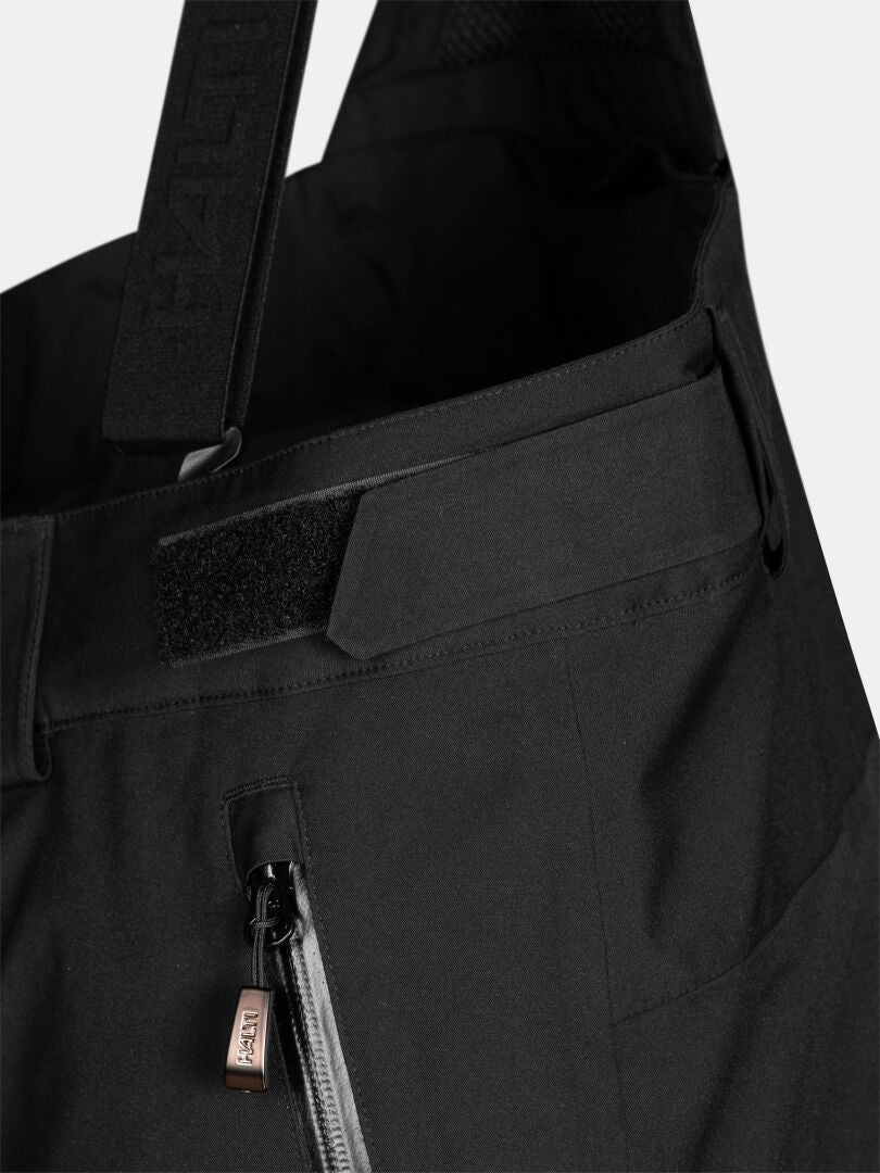 Close-up of Halti Vertica II DX Ski Pants for men, featuring adjustable waist straps and a zippered pocket.