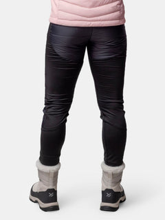 Person wearing Halti Veidnes Insulation Pants Womens, a pink jacket, and light winter boots, shown from the back.