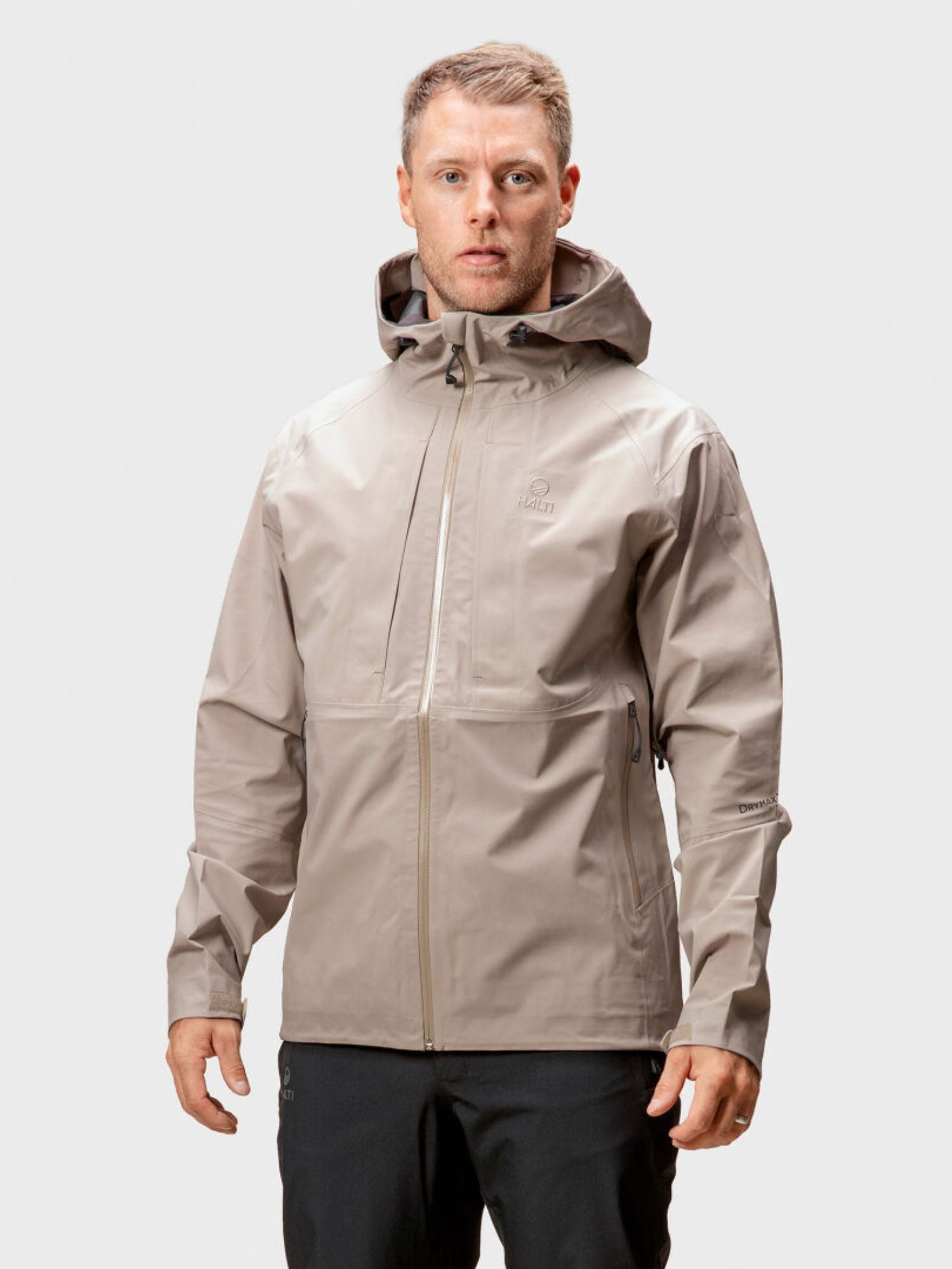 A man faces forward wearing the Halti Kaarna Mens DX 3L Shell Jacket and black pants against a plain white background.