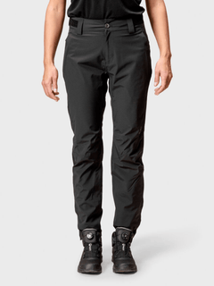 Model wearing Halti Juonto Womens Shell Pants and black athletic shoes, shown from shoulders to feet against a plain backdrop.