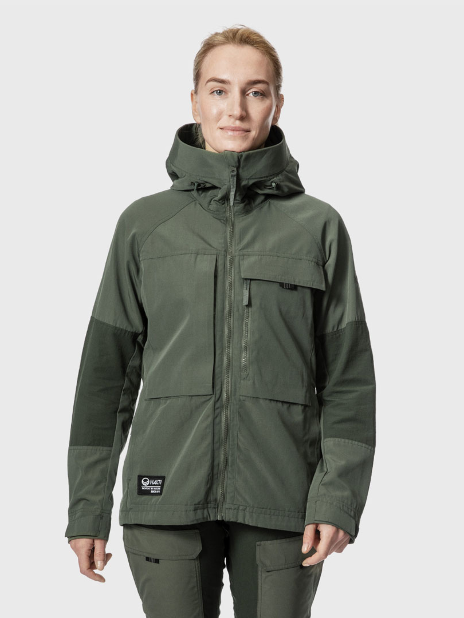 A person wears the Halti Hiker Women's Ventilated Jacket in olive green, facing forward against a light gray background.