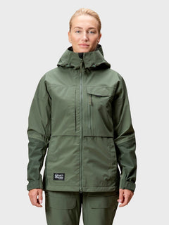 A woman wears a green Halti Hiker Drymaxx 3L Ventilated Jacket and pants, facing forward against a plain background.