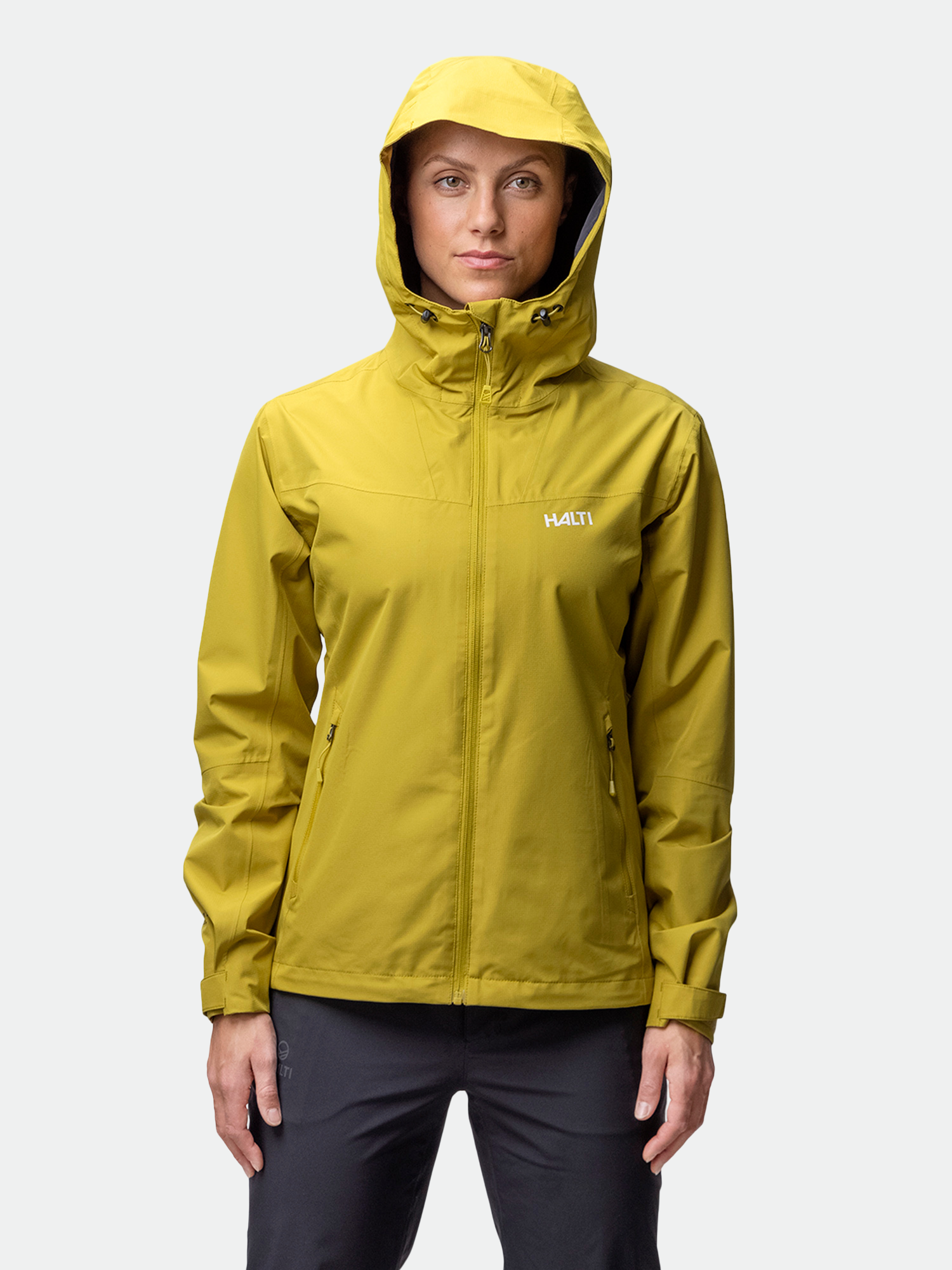 A woman wears the Halti Forter DX Shell Jacket in yellow, facing forward against a plain light background.