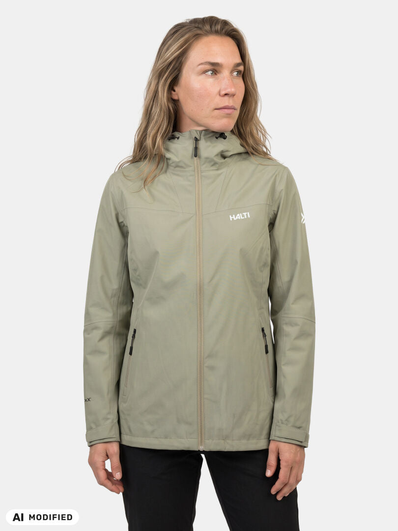 Woman in a light olive Halti Forter DX Shell Jacket with zip pockets, standing against a plain white background.