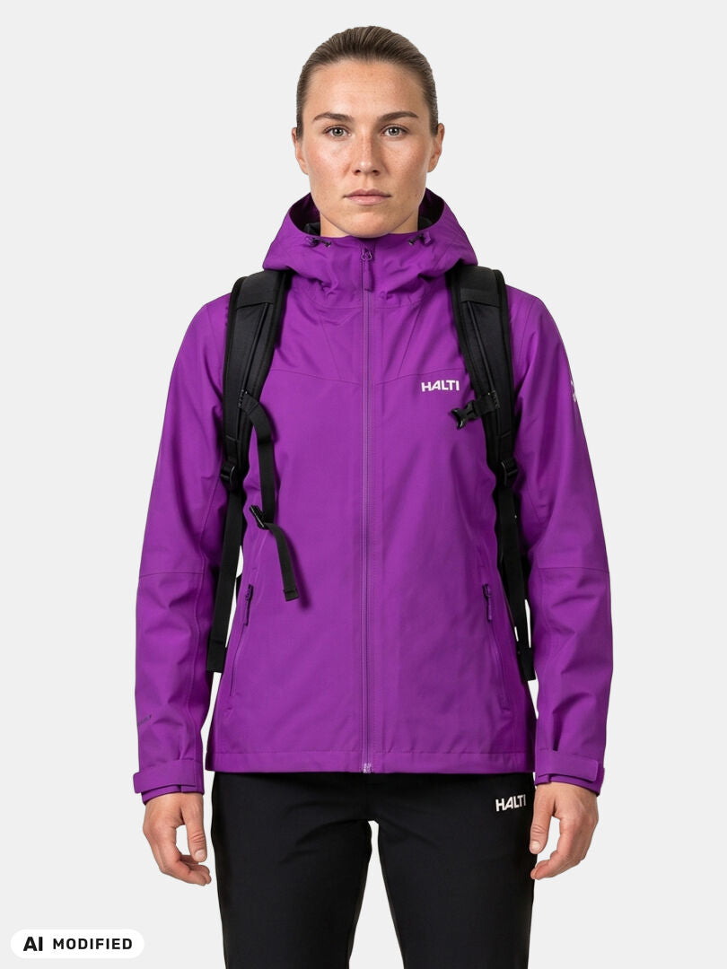 Woman in a purple Halti Forter DX Shell Jacket with a black backpack, standing against a plain white background.